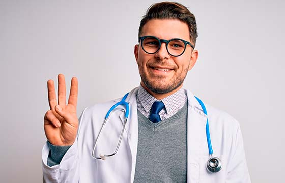 мужчина врач в очках показывает три пальца
